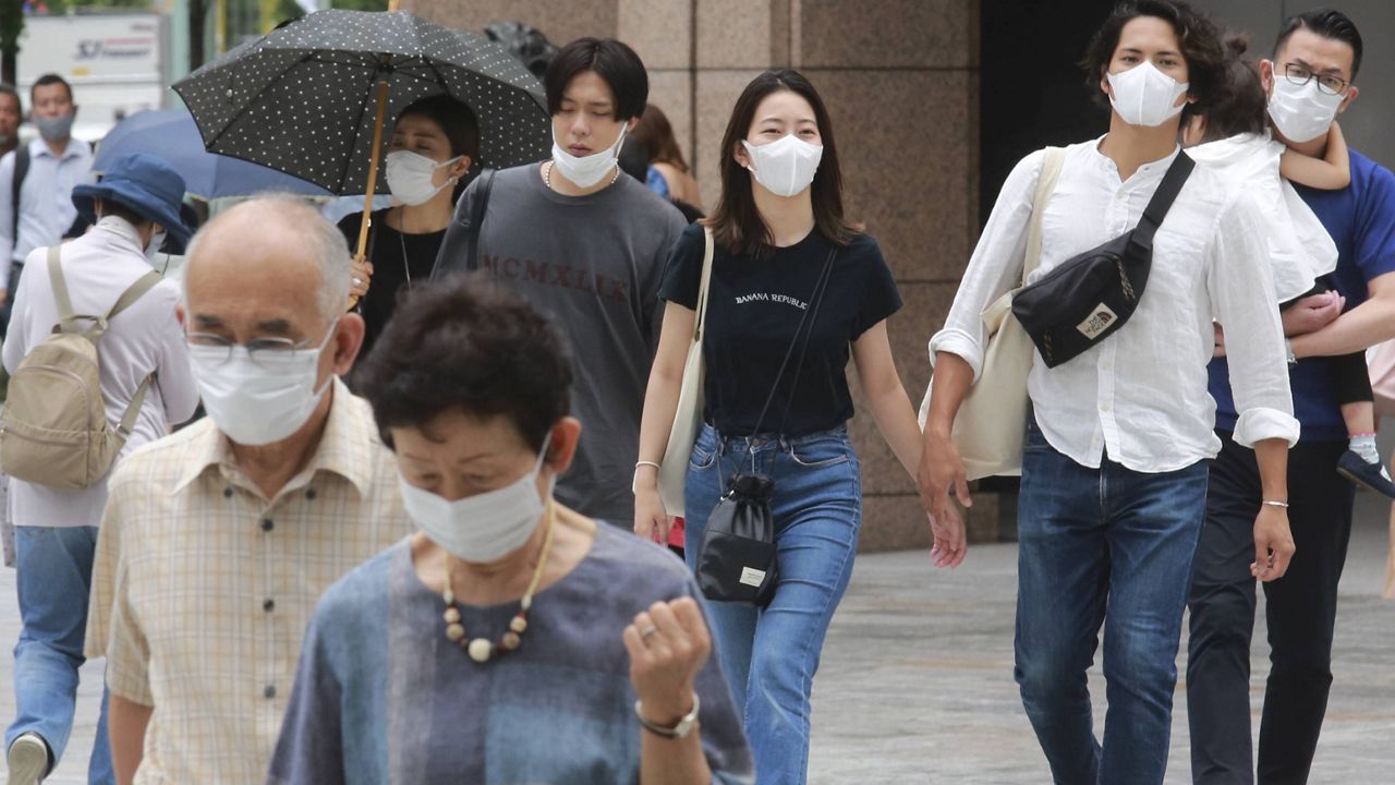 People wearing face masks walk on a street in Tokyo on Tuesday. (AP Photo/Koji Sasahara)