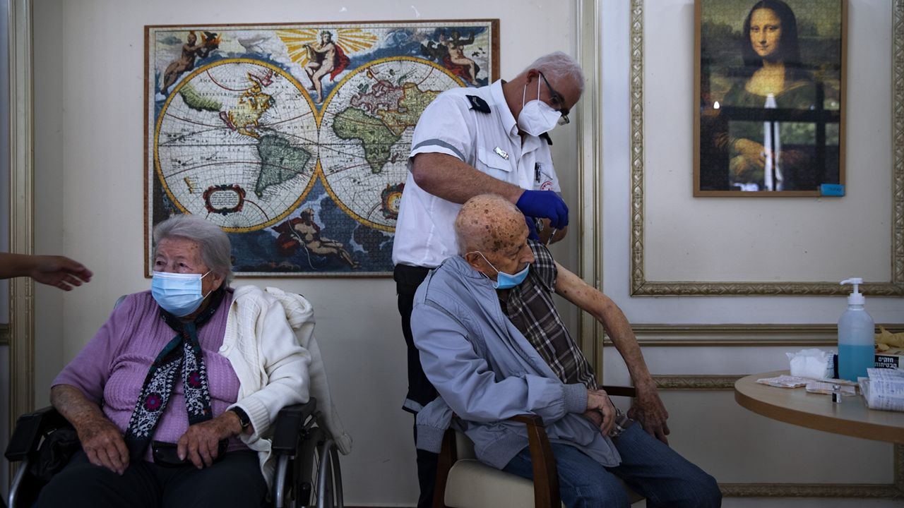 FILE - In this Jan. 13, 2021 file photo, a man receives his second Pfizer-BioNTech COVID-19 vaccine from a Magen David Adom national emergency service volunteer, at a private nursing home, in Ramat Gan, Israel. (AP Photo/Oded Balilty, File)