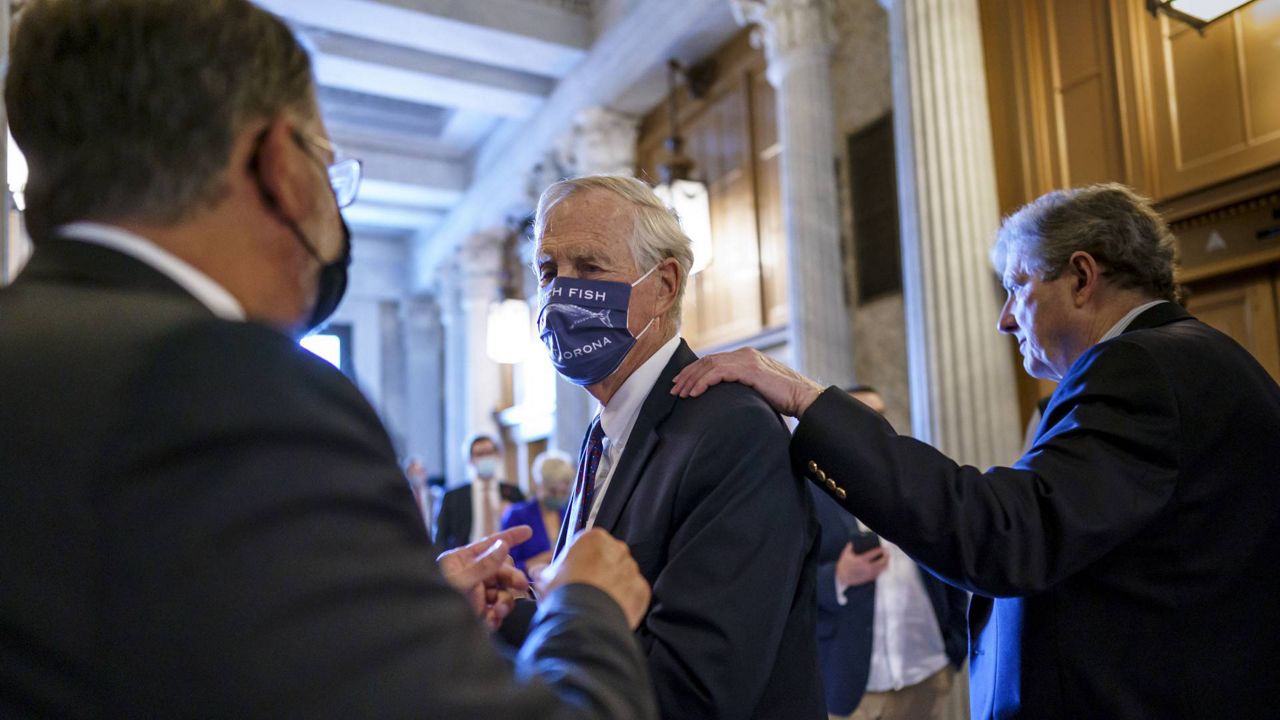 Sen. Angus King, I-Maine, center, speaks with Sen. Gary Peters, D-Mich., left, while Sen. John Kennedy, R-La., walks by at right, as the Senate votes to formally begin debate on the infrastructure plan at the Capitol in Washington, Friday, July 30, 2021. (AP Photo/J. Scott Applewhite)
