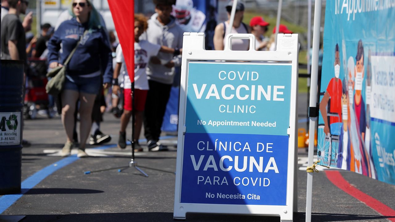 A sign for a mobile coronavirus vaccine clinic is displayed during a New England Patriots NFL football practice at Gillette Stadium, Saturday, July 31, 2021, in Foxborough, Mass. (AP Photo/Michael Dwyer)