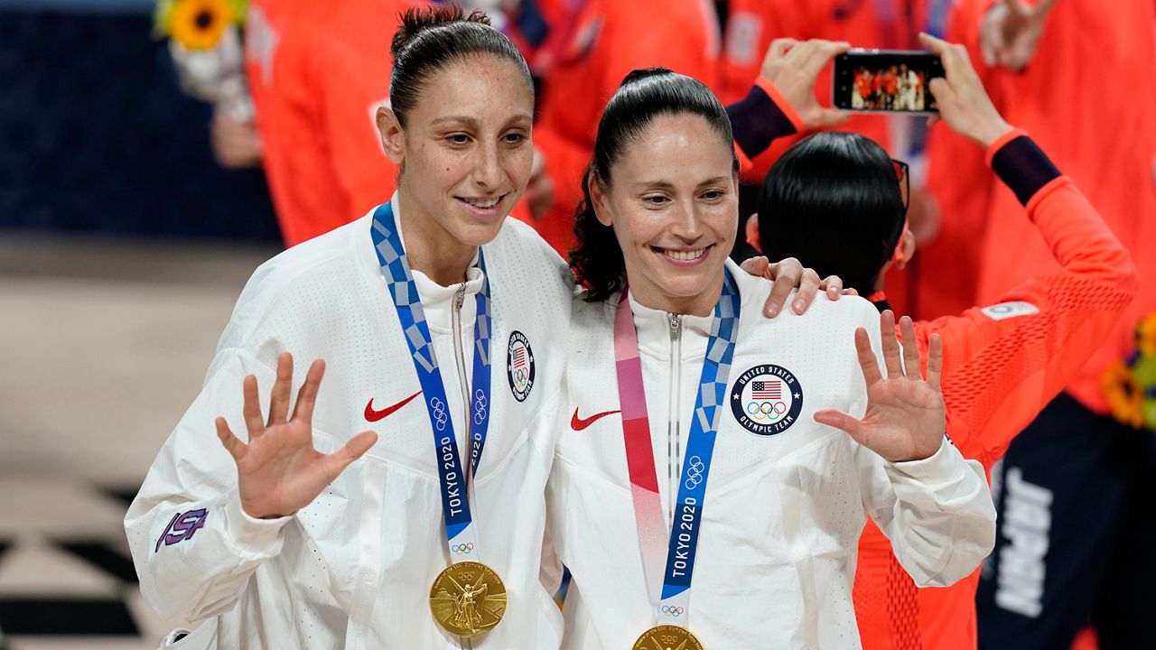 United States's Sue Bird, right, and Diana Taurasi pose with their gold medals for women's basketball at the 2020 Summer Olympics in Saitama, Japan. (AP Photo/Charlie Neibergall)