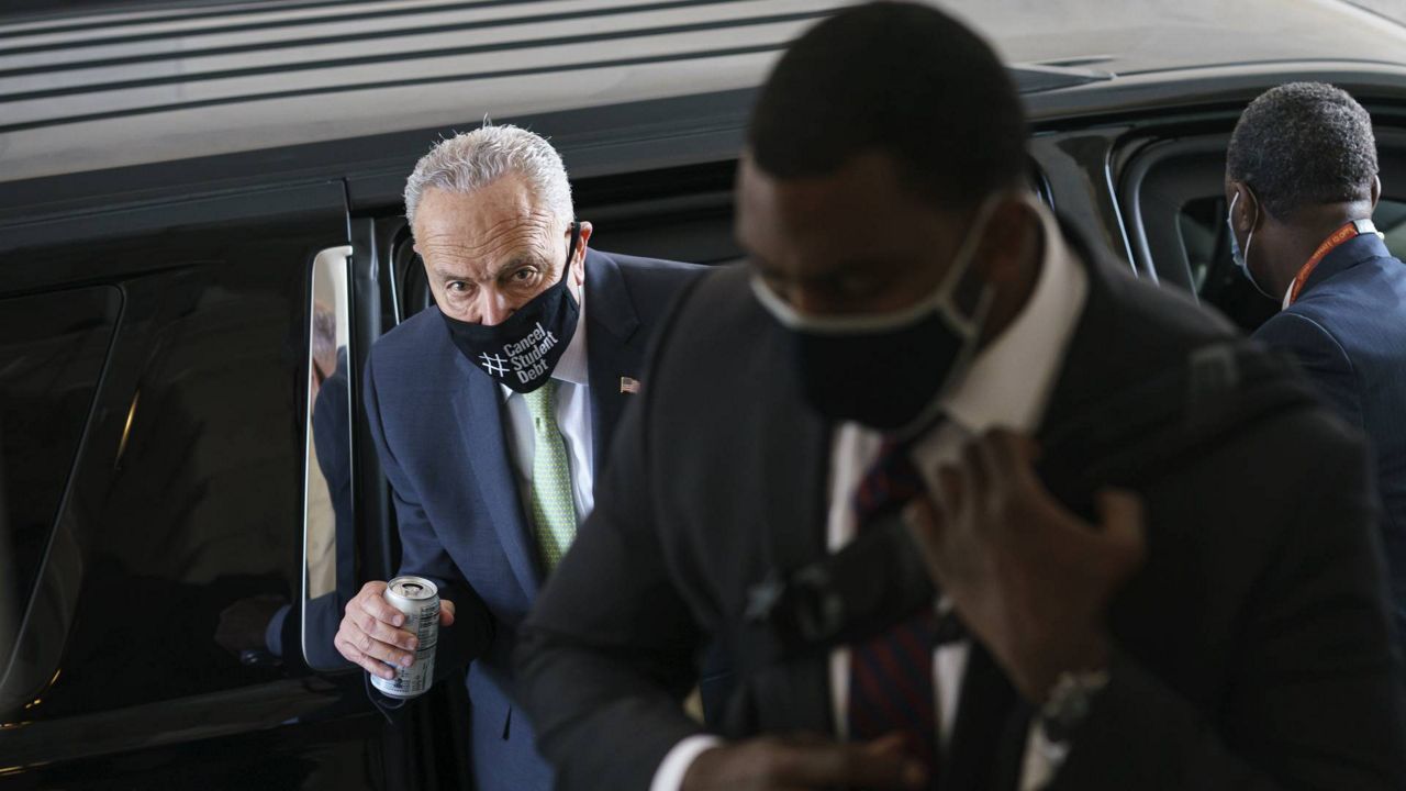 Senate Majority Leader Chuck Schumer, D-N.Y., arrives with his security detail as senators convene to continue work on the infrastructure bill, at the Capitol in Washington, Sunday, Aug. 8, 2021. (AP Photo/J. Scott Applewhite)