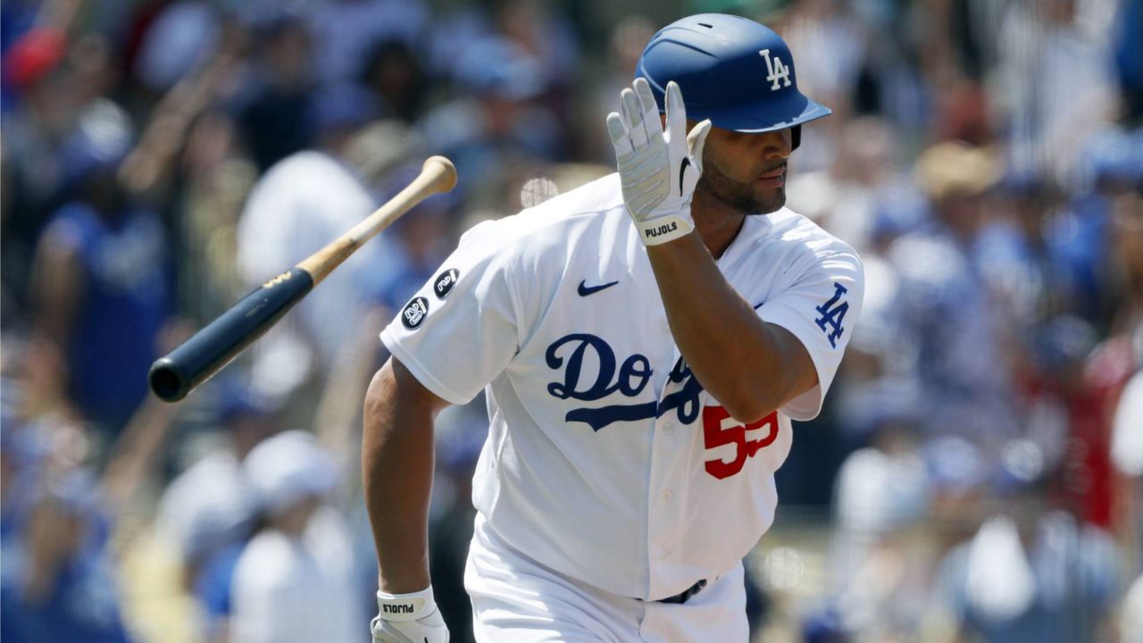 Dodgers' Albert Pujols throws his bat after hitting a two-run home run against the Angels during the second inning of a baseball game in Los Angeles, Sunday, Aug. 8, 2021. (AP Photo/Alex Gallardo)