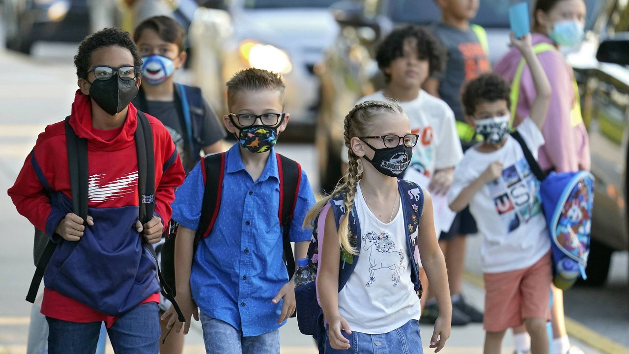 Students, some wearing protective masks, arrive for the first day of school Tuesday at Sessums Elementary School in Riverview, Fla. (AP Photo/Chris O'Meara)