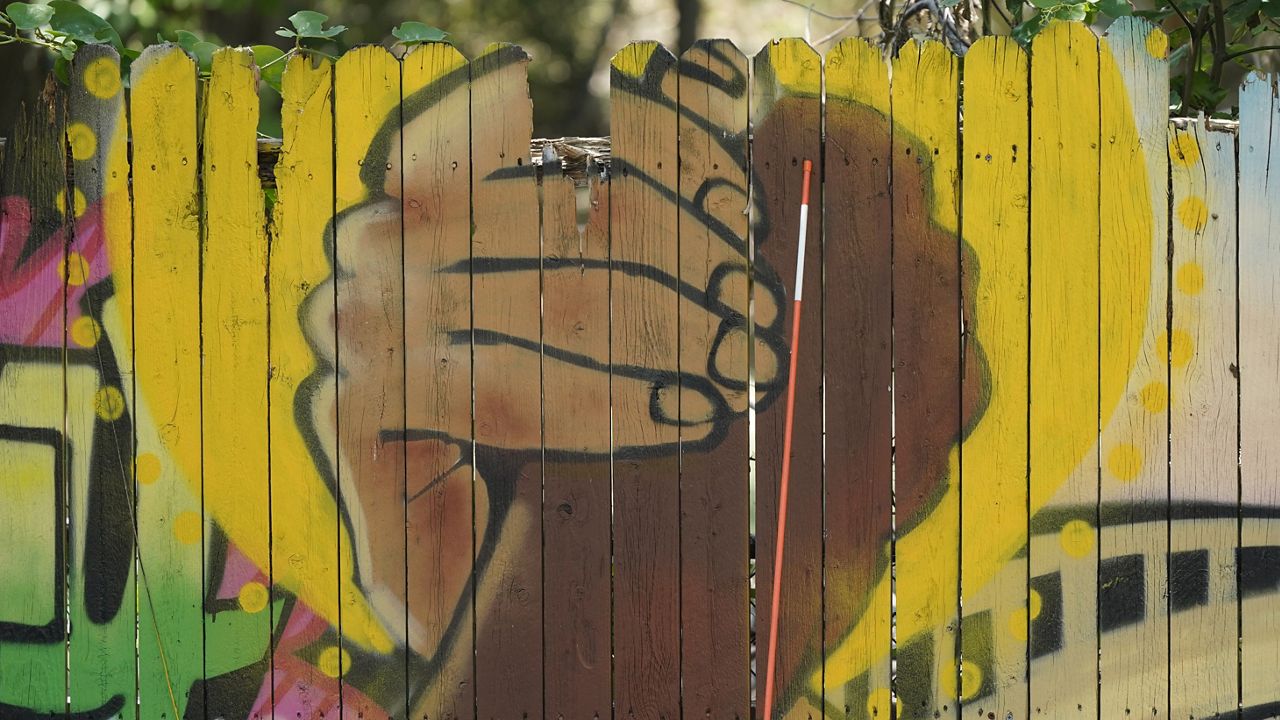 A mural on a fence is displayed at United Fort Worth, a grassroots community organization in Fort Worth, Texas, Tuesday, Aug. 10, 2021. (AP Photo/LM Otero).