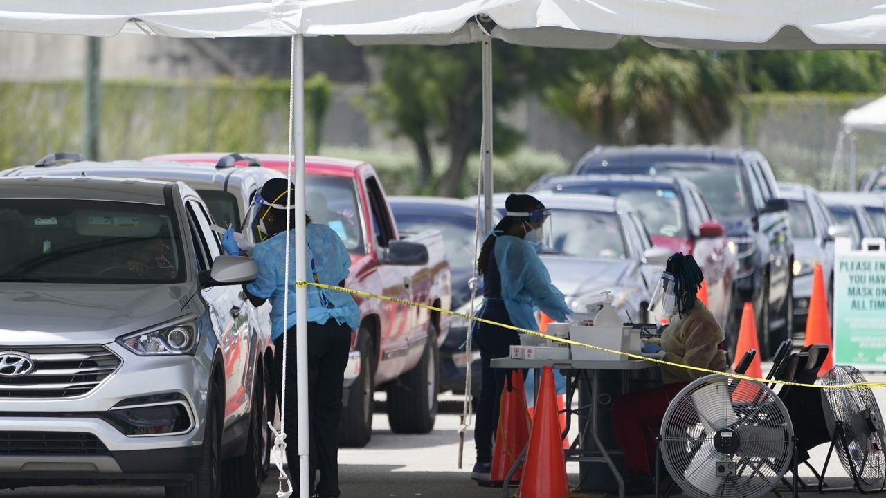 People wait in cars to get a COVID-19 test, Wednesday, Aug. 11, 2021, in Miami. (AP Photo/Marta Lavandier)