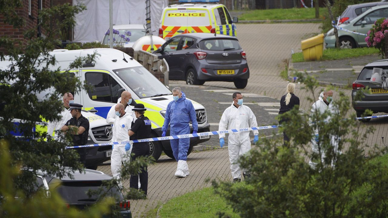 Forensic officers walk in Biddick Drive in the Keyham area of Plymouth, England Friday Aug. 13, 2021 where six people were killed in a shooting incident. (Ben Birchall/PA via AP)