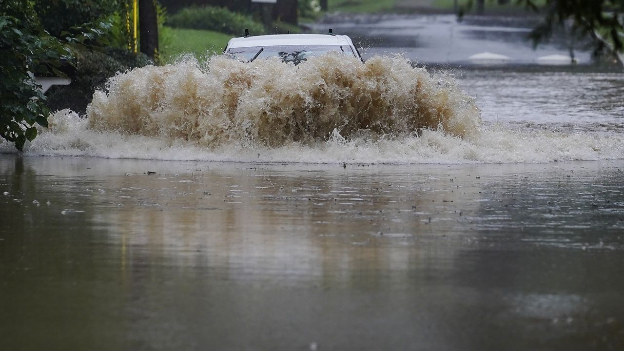 A car attempts to drive through flood waters near Peachtree Creek near Atlanta, as Tropical Storm Fred makes its way through north and central Georgia on Tuesday, Aug. 17, 2021. (AP Photo/Brynn Anderson)