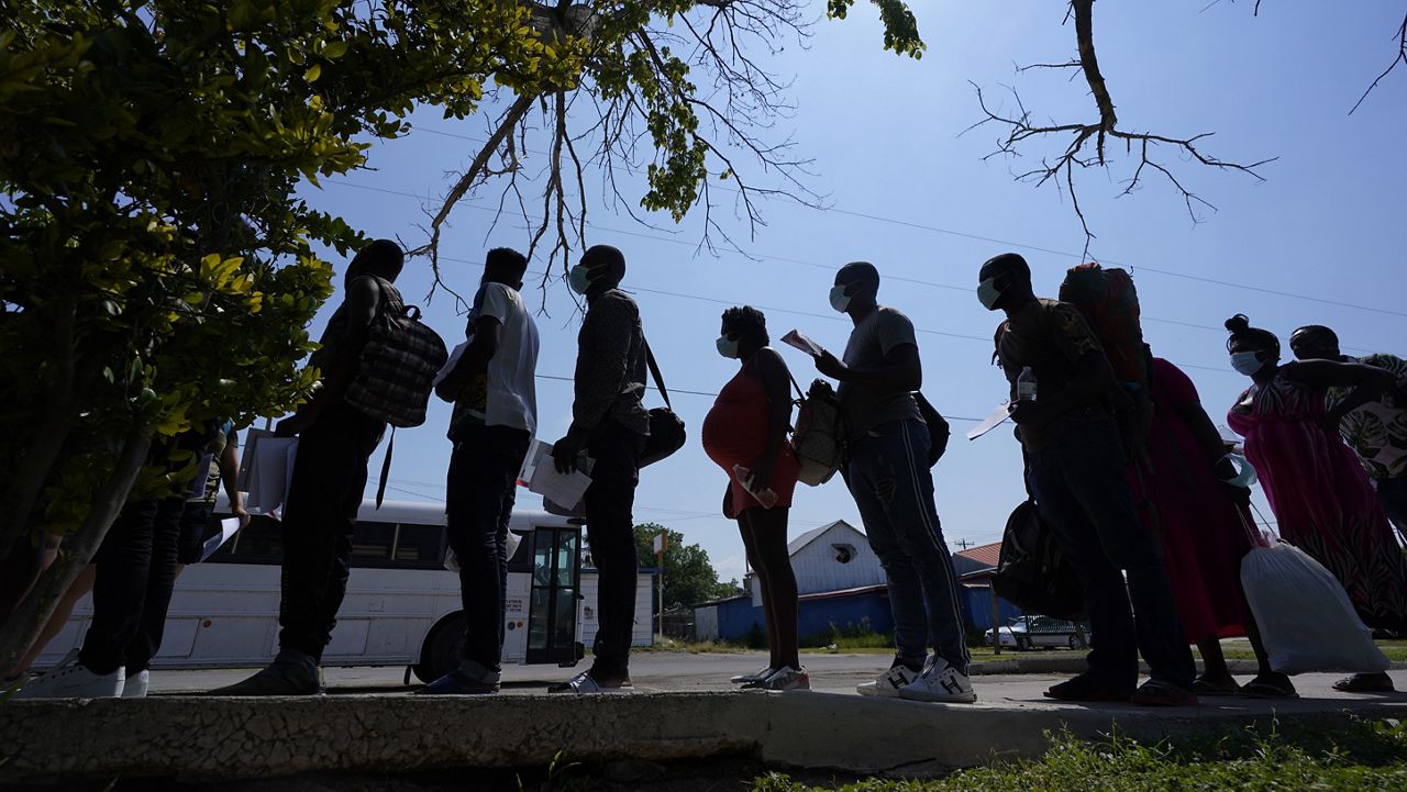 In this June 16, 2021, file photo migrants stand stand in line at a respite center after they crossed the U.S.-Mexico border and turned themselves in and were released in Del Rio, Texas. (AP Photo/Eric Gay, File)