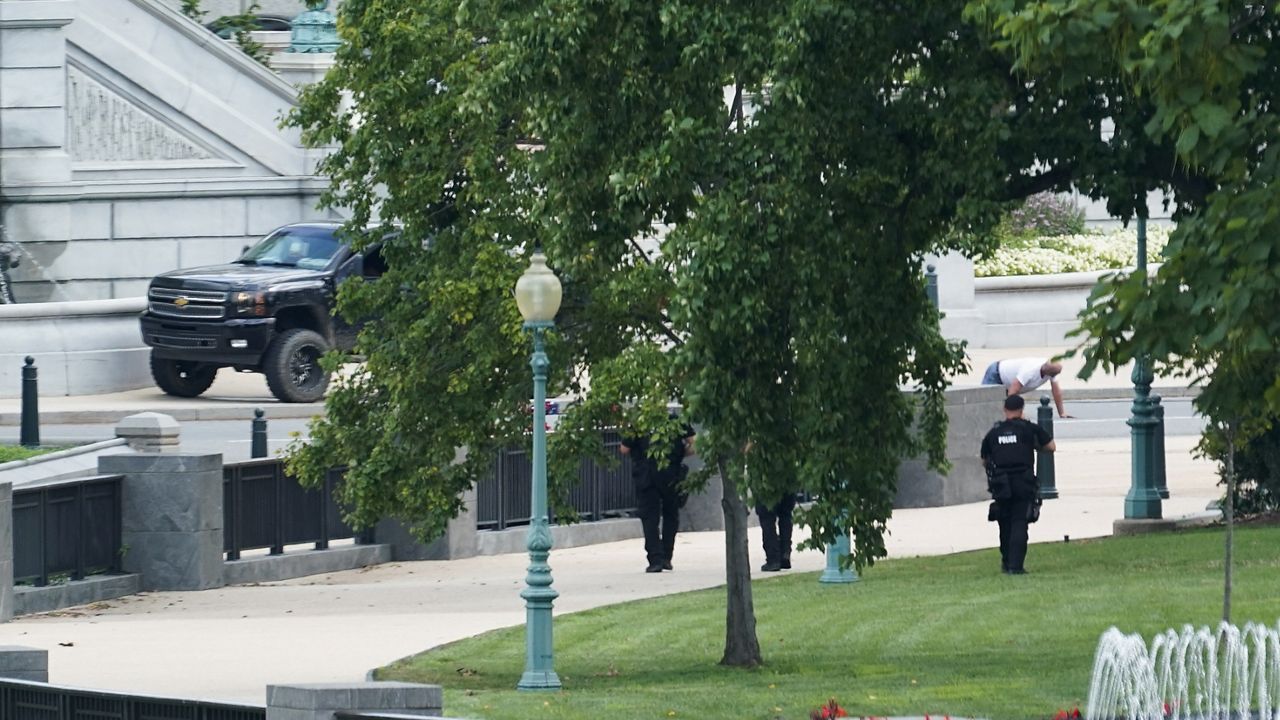 A person is apprehended after being in a pickup truck parked on the sidewalk in front of the Library of Congress' Thomas Jefferson Building, as seen from a window of the U.S. Capitol, Thursday, Aug. 19, 2021, in Washington. (AP Photo/Alex Brandon)