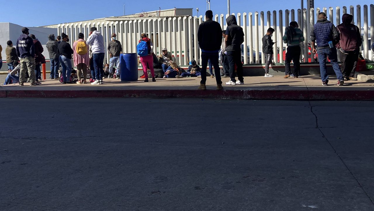 Migrants waiting to cross into the United States wait for news at the border crossing Wednesday, Feb. 17, 2021, in Tijuana, Mexico. (AP Photo/Elliot Spagat)