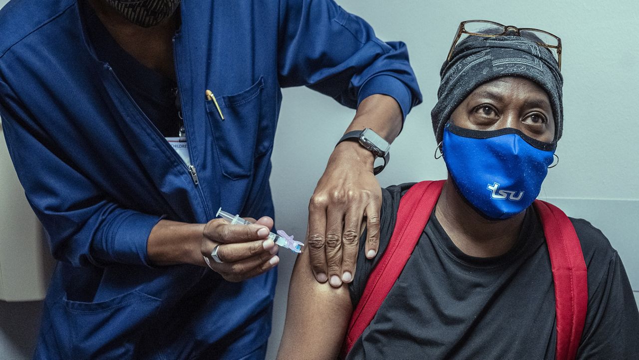 Ricky Whitson receives her second shot of the Moderna COVID-19 vaccine from Ron Childress at Nashville General Hospitall in Nashville, Tenn., Friday, Aug. 20, 2021. (AP Photo/John Partipilo)