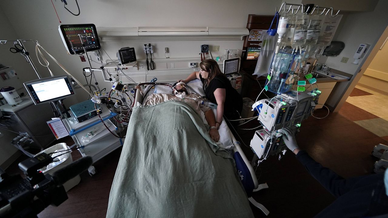 Lauren Debroeck, who is on oxygen as she recovers from COVID-19, talks to her husband, Michael, who also contracted COVID-19 and is being kept alive with the help of an oxygenation machine, at the Willis-Knighton Medical Center in Shreveport, La., on Aug. 18. (AP Photo/Gerald Herbert)