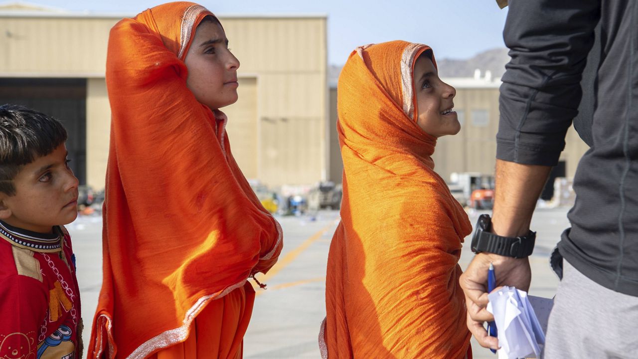 In this image provided by the U.S. Air Force, people being evacuated from Afghanistan wait to board a U.S. Air Force C-17 Globemaster III at Hamid Karzai International Airport in Kabul, Afghanistan, Tuesday, Aug. 24, 2021. (Master Sgt. Donald R. Allen/U.S. Air Force via AP)