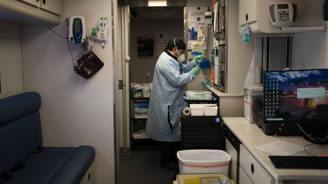 Parsia Jahanbani prepares a syringe with the Pfizer COVID-19 vaccine in a mobile vaccine clinic operated by Families Together of Orange County, Aug. 26, 2021, in Santa Ana, Calif. (AP Photo/Jae C. Hong)