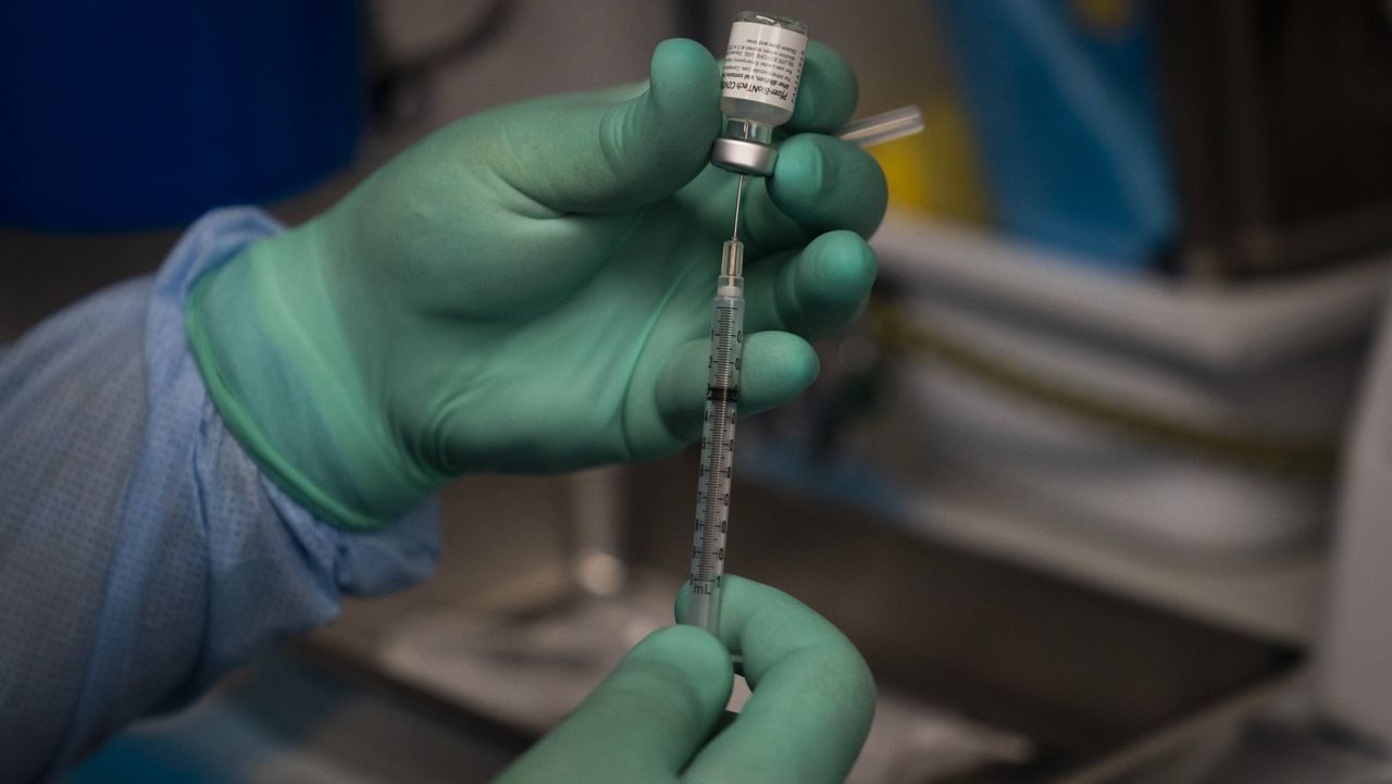 Parsia Jahanbani prepares a syringe with the Pfizer COVID-19 vaccine in a mobile vaccine clinic operated by Families Together of Orange County Thursday, Aug. 26, 2021, in Santa Ana, Calif. (AP Photo/Jae C. Hong)