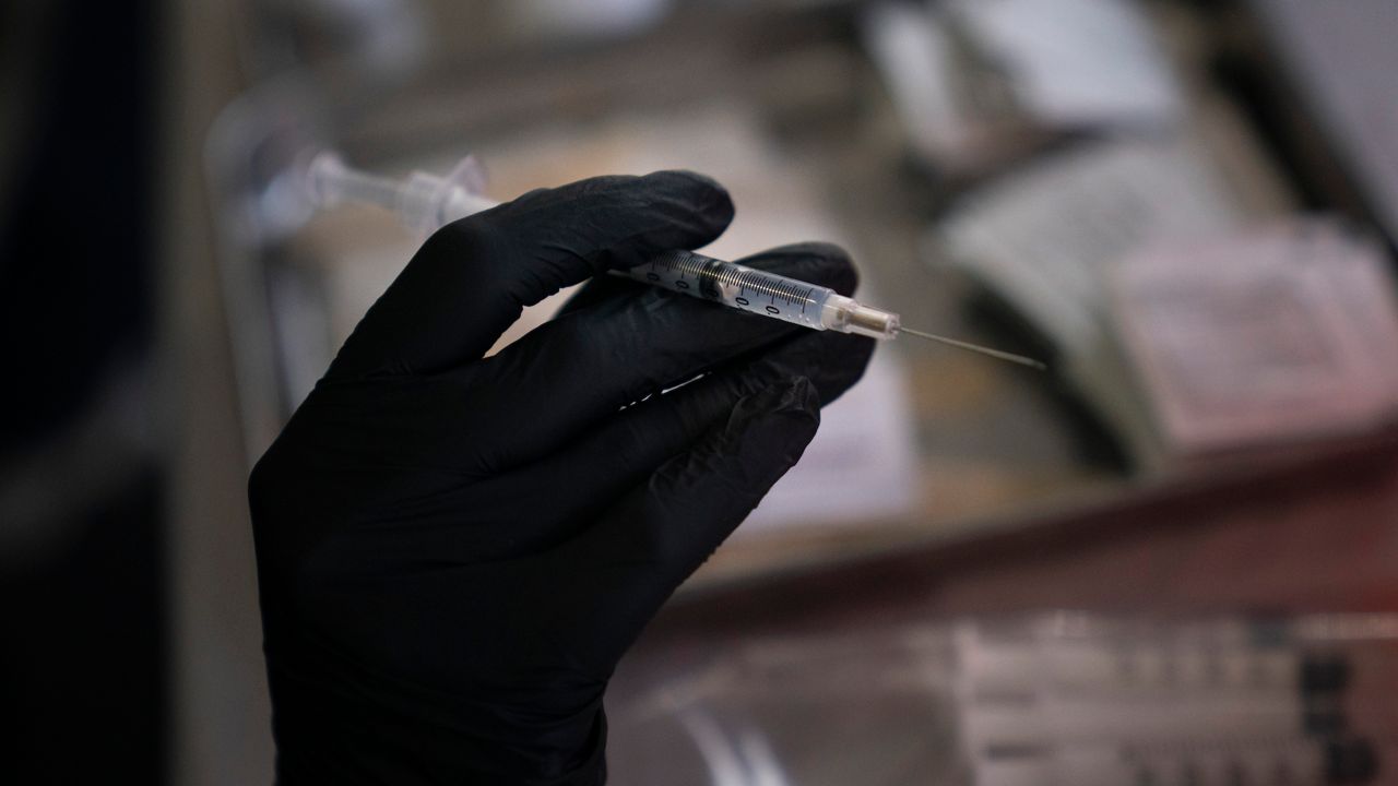 Pharmacy intern Jasmine Hana holds a syringe with the COVID-19 vaccine at a vaccine clinic set up in the parking lot of CalOptima Saturday, Aug. 28, 2021, in Orange, Calif. (AP Photo/Jae C. Hong)