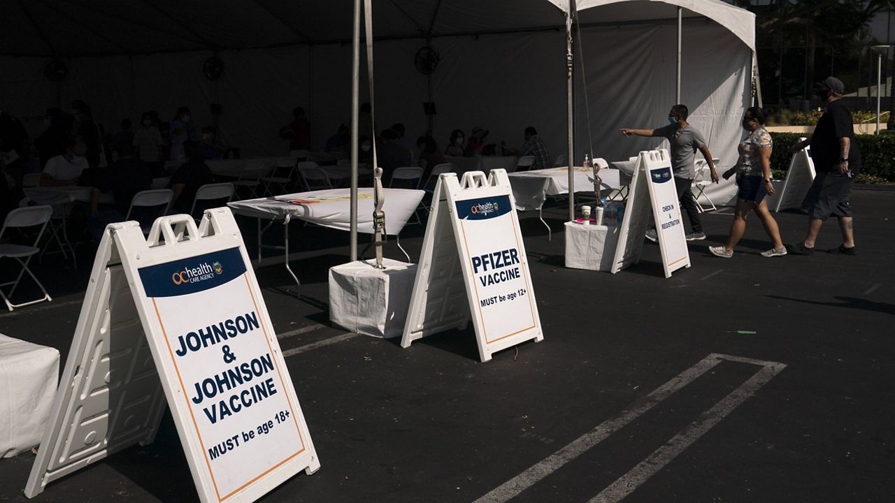 People walk into a vaccine clinic set up in the parking lot of CalOptima Saturday, Aug. 28, 2021, in Orange, Calif. (AP Photo/Jae C. Hong)