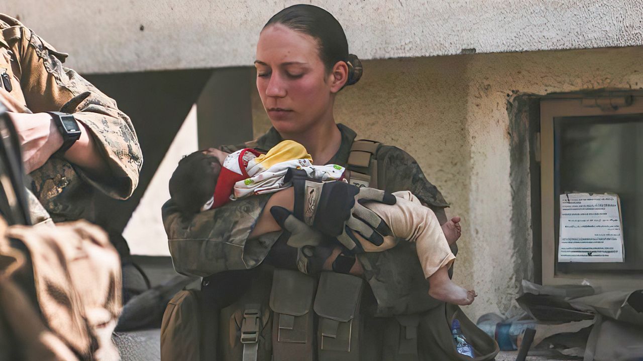 In this Aug. 20, 2021, image provided by the U.S. Marine Corps, Marines assigned to the 24th Marine Expeditionary Unit (MEU), including Sgt. Nicole Gee calms an infant during an evacuation at Hamid Karzai International Airport in Kabul, Afghanistan. Officials said Aug. 28, that Gee of Sacramento, Calif., was one of the Marines killed in Thursday's bombing at the airport. (Sgt. Isaiah Campbell/U.S. Marine Corps via AP)