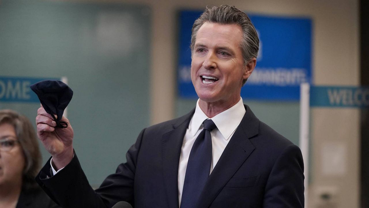 In this July 26, 2021, file photo, Gov. Gavin Newsom holds a face mask while speaking at a news conference in Oakland, Calif. (AP Photo/Jeff Chiu)