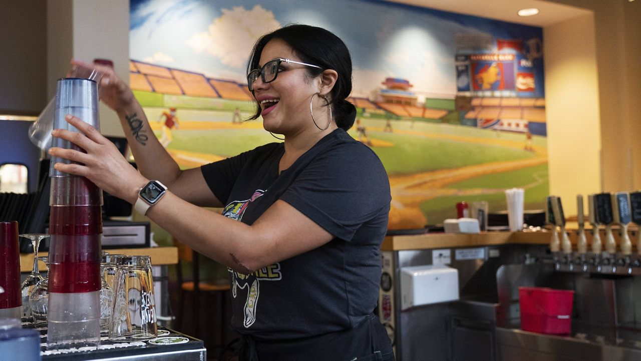 Karen Rosa, a bartender who was newly hired this year, works the bar at the Lost Dog Cafe, in Fairfax, Va., on Aug. 27. rything from age to level of experience. (AP Photo/Jacquelyn Martin)