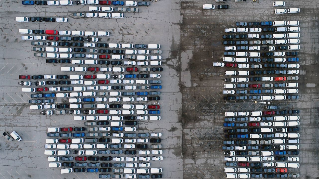 Mid-sized pickup trucks and full-size vans are seen in a parking lot outside a General Motors assembly plant in Wentzville, Mo. (AP Photo/Jeff Roberson, File)