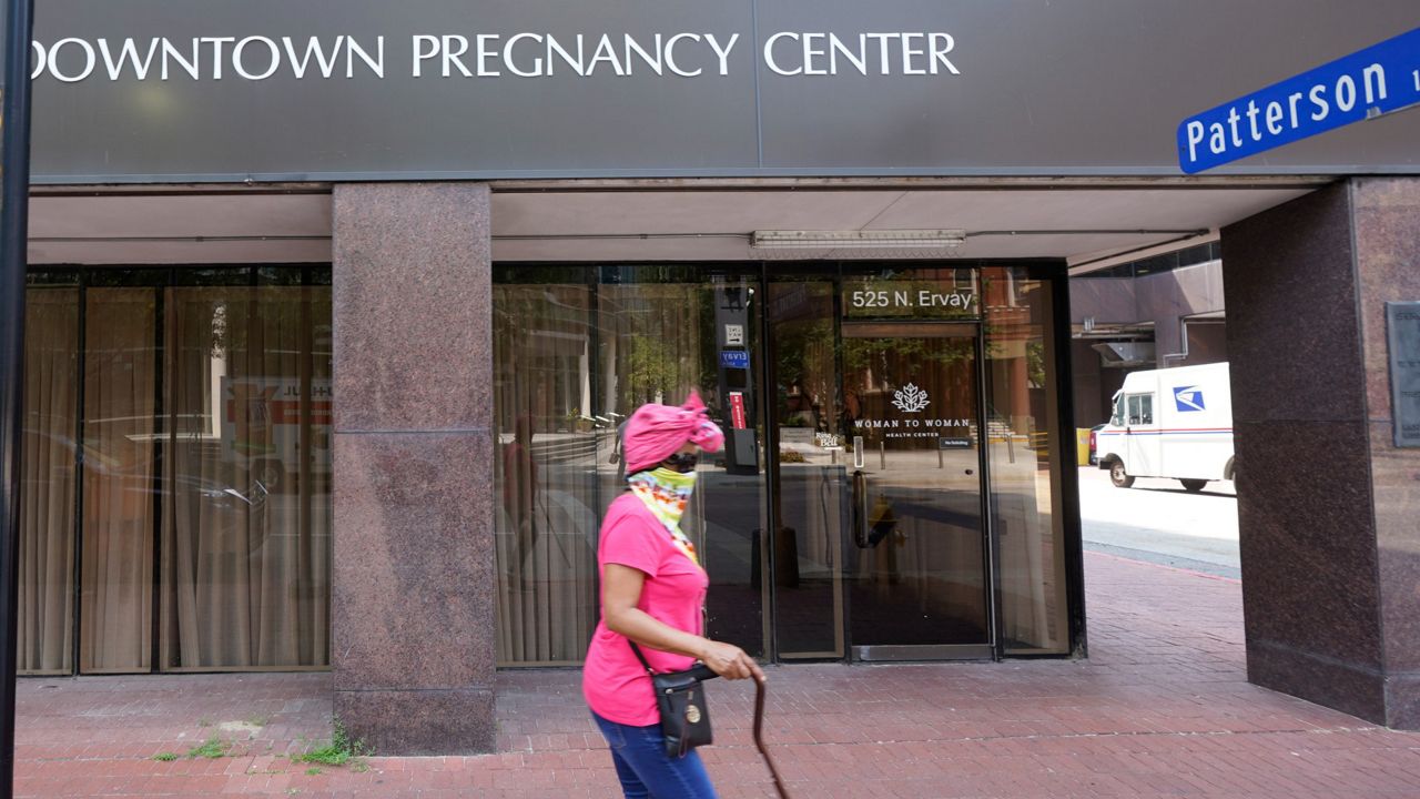 A woman walks by the Woman to Woman Health Center in downtown Dallas Thursday, Sept. 2, 2021. (AP Photo/LM Otero)