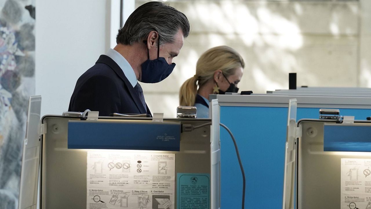 California Gov. Gavin Newsom, and his wife First Partner Jennifer Siebel Newsom mark their ballots at a voting center in Sacramento, Calif., Friday, Sept. 10, 2021.