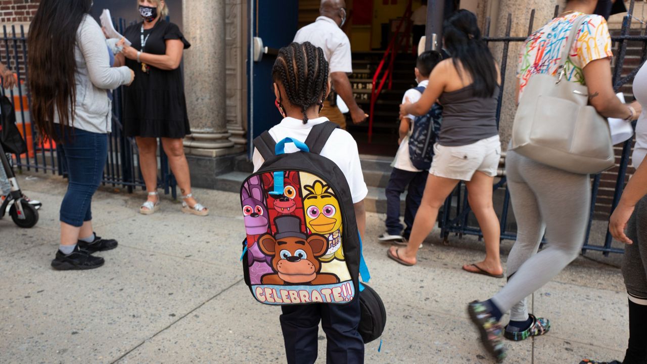 A boy walks into Brooklyn's PS 245, Monday, Sept. 13, 2021, in New York. (AP Photo/Mark Lennihan)