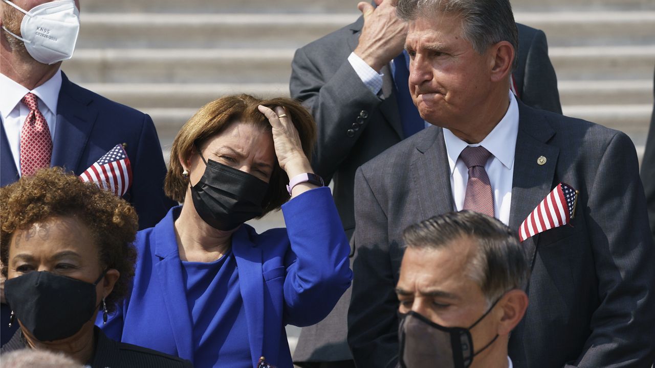 Sen. Amy Klobuchar, D-Minn., left, and Sen. Joe Manchin, D-W.Va., stand on the steps of the Capitol during a Sept. 11 remembrance ceremony, in Washington, Monday, Sept. 13, 2021. (AP Photo/J. Scott Applewhite)