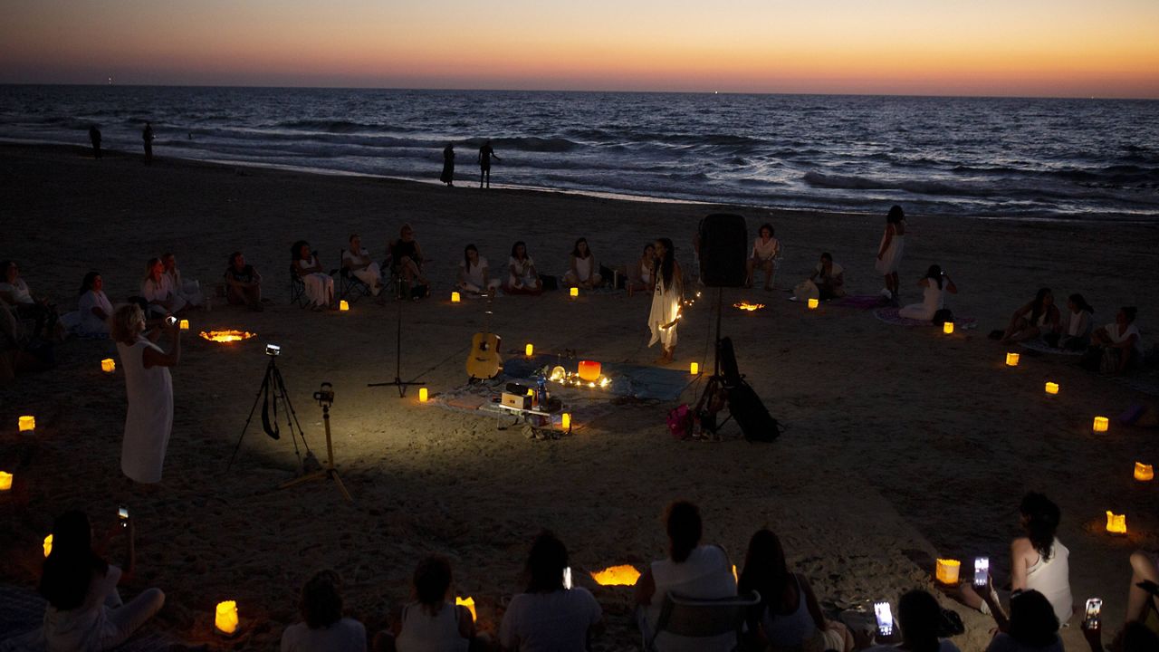 Women take part in a Tashlich ceremony, where they wrote down things they want to release before casting them into a fire, on the beach in Tel Aviv, Israel, Tuesday, Sept. 14, 2021. (AP Photo/Maya Alleruzzo)