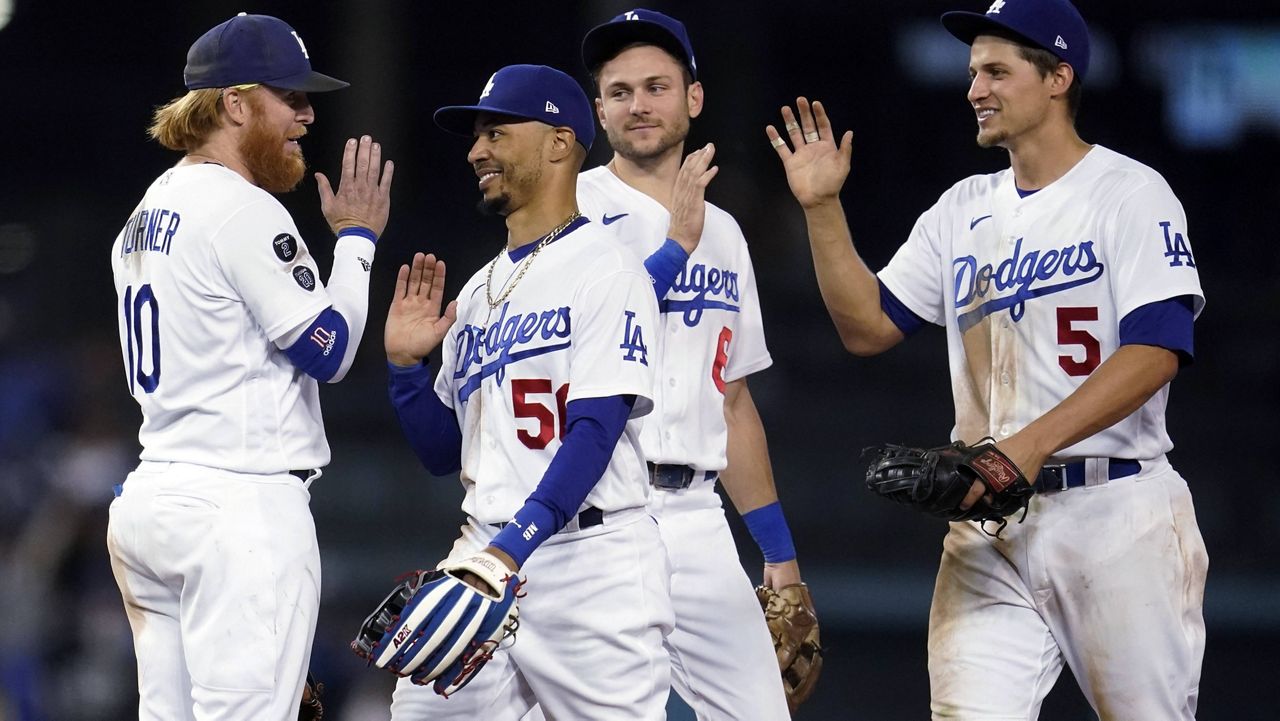 Los Angeles Dodgers' Justin Turner, Mookie Betts, Trea Turner and Corey Seager, from left, celebrate the team's 8-4 win over the Arizona Diamondbacks in a baseball game Tuesday, Sept. 14, 2021, in Los Angeles. (AP Photo/Marcio Jose Sanchez)