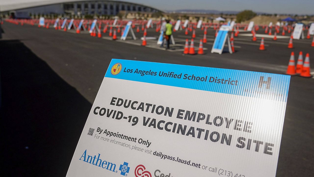 In this March 2, 2021, file photo, a sign is displayed at a COVID-19 vaccination site for employees of the Los Angeles School District, LAUSD, in the parking lot of SOFI Stadium in Inglewood, Calif. (AP Photo/Marcio Jose Sanchez, File)