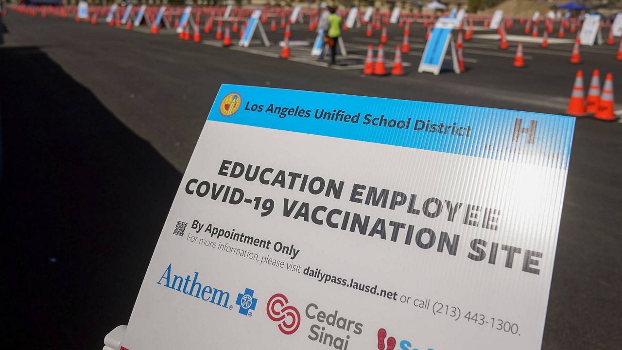 In this March 2, 2021, file photo, a sign is displayed at a COVID-19 vaccination site for employees of the Los Angeles School District, LAUSD, in the parking lot of SOFI Stadium in Inglewood, Calif. (AP Photo/Marcio Jose Sanchez)