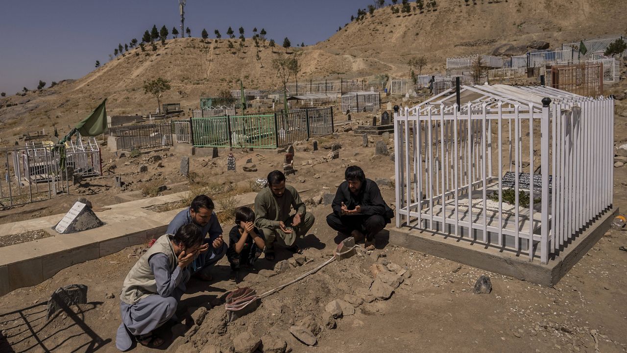 The Ahmadi family prays Monday at the cemetery next to graves of relatives killed by a U.S. drone strike in Kabul, Afghanistan.  (AP Photo/Bernat Armangue, File)