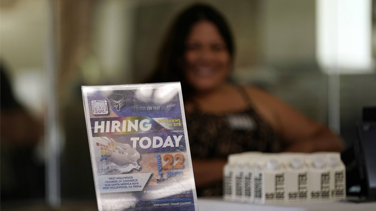 A hiring sign is placed at a booth for prospective employers during a job fair Sept. 22 in the West Hollywood section of Los Angeles. (AP Photo/Marcio Jose Sanchez)
