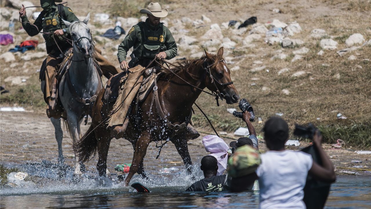 FILE - In this Sept. 19, 2021, file photo, U.S. Customs and Border Protection mounted officers attempt to contain migrants as they cross the Rio Grande from Ciudad Acuña, Mexico, into Del Rio, Texas. (AP Photo/Felix Marquez, File)