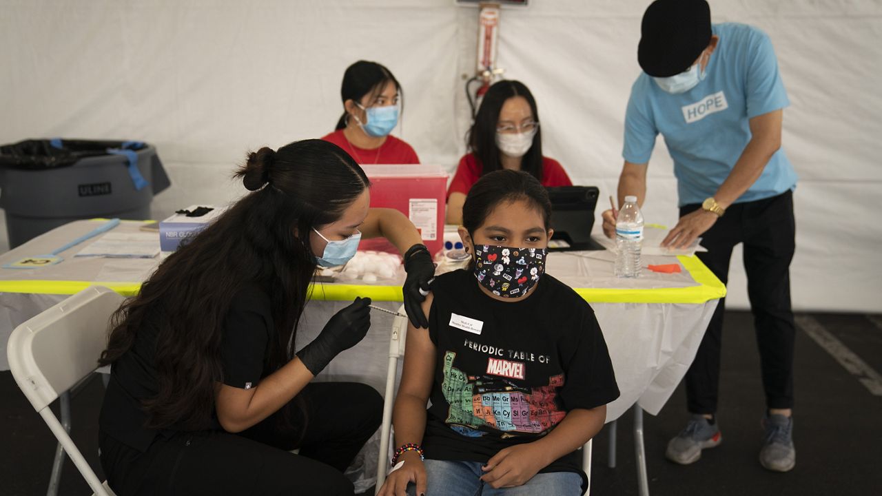 FILE - In this Aug. 28, 2021, file photo, Mayra Navarrete, 13, receives the Pfizer COVID-19 vaccine from registered nurse, Noleen Nobleza at a clinic set up in the parking lot of CalOptima in Orange, Calif. (AP Photo/Jae C. Hong, File)