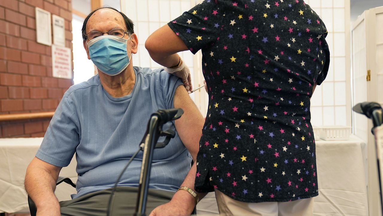Marvin Marcus, 79, a resident at the Hebrew Home at Riverdale, receives a COVID-19 booster shot in New York, Monday, Sept. 27, 2021. (AP Photo/Seth Wenig)
