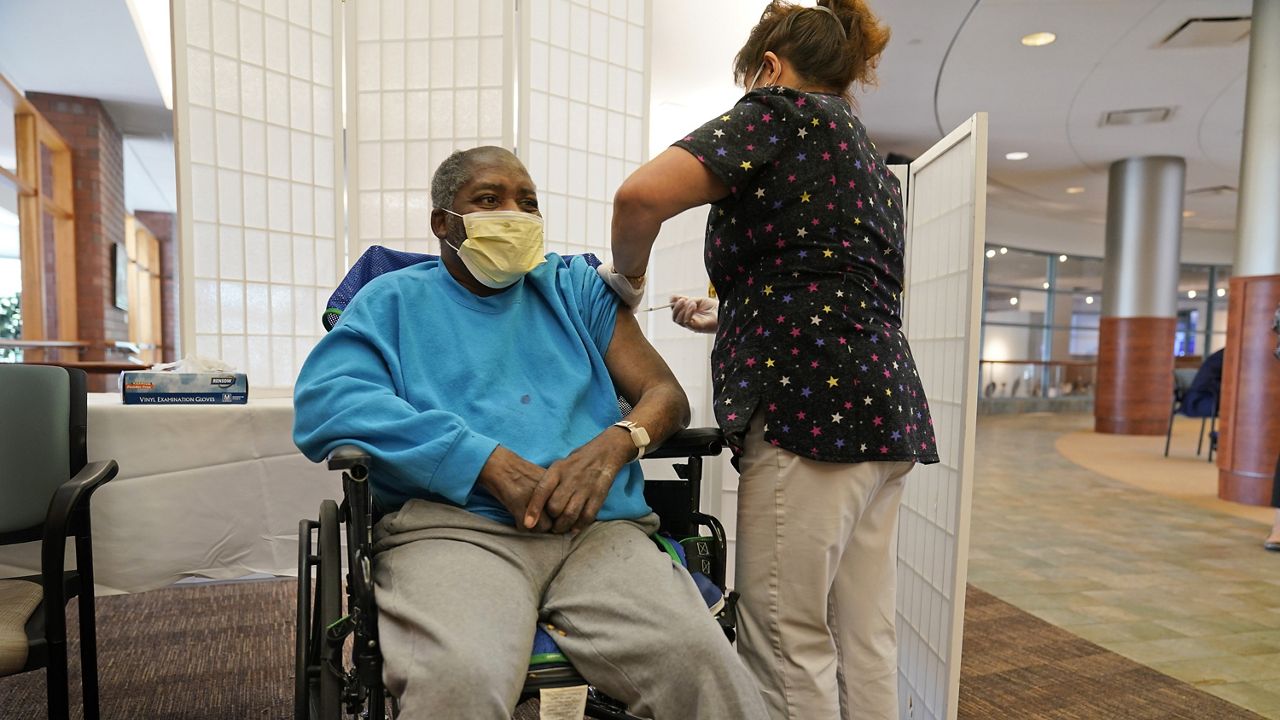 Edward Williams, 62, a resident at the Hebrew Home at Riverdale, receives a COVID-19 booster shot in New York, Monday, Sept. 27, 2021. (AP Photo/Seth Wenig)