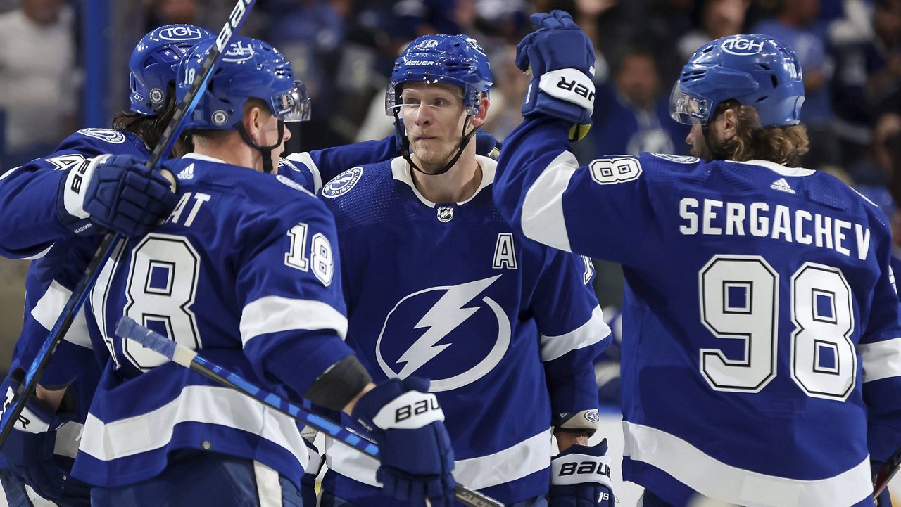 The Tampa Bay Lightning's Ondrej Palat (18) and Mikhail Sergachev (98) congratulate Corey Perry (center) after his goal against the Carolina Hurricanes during a preseason game Oct. 1 in Tampa, Fla. (AP Photo/Mike Carlson)