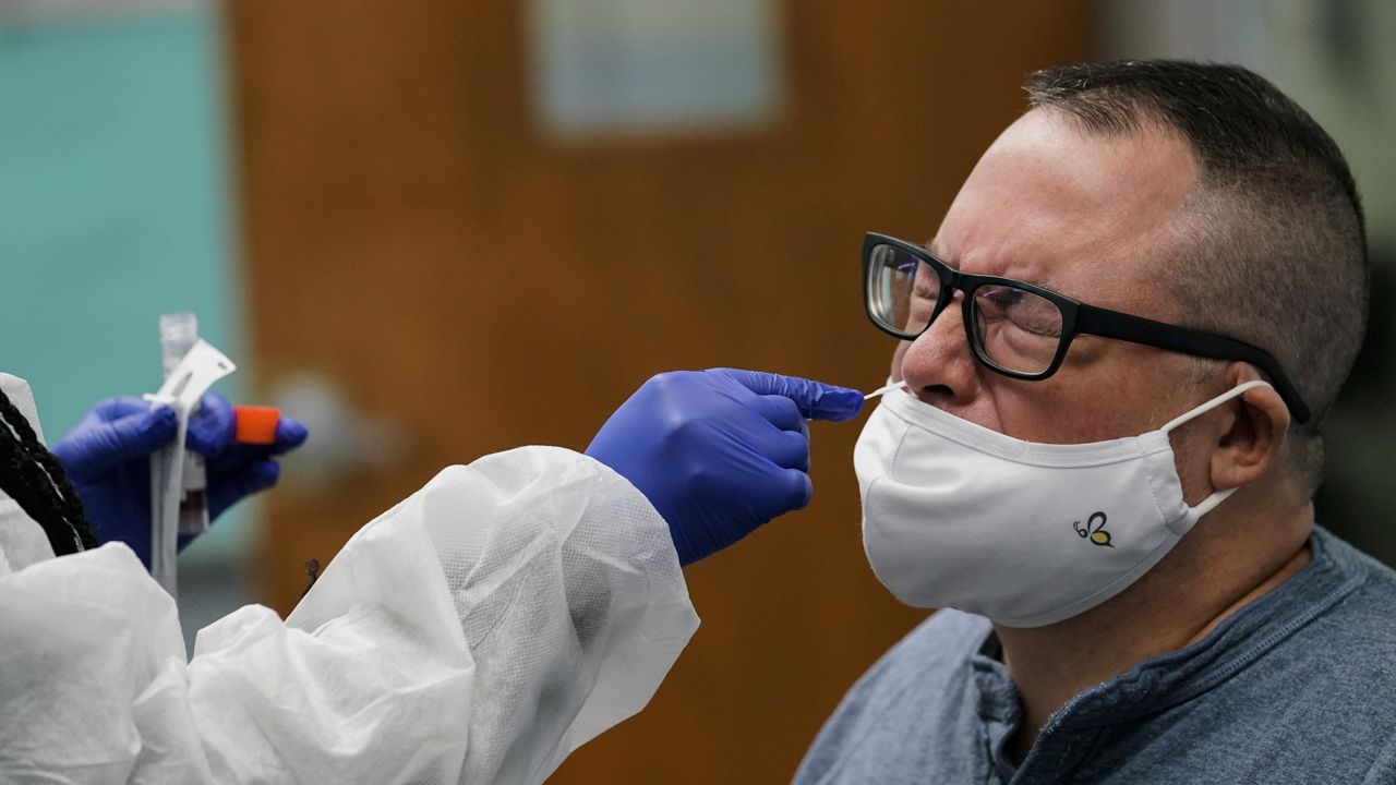 FILE - English teacher Frank Esposito receives a COVID-19 nasal swab test at West Brooklyn Community High School in New York, on Thursday Oct. 29, 2020. (AP Photo/Kathy Willens, File)