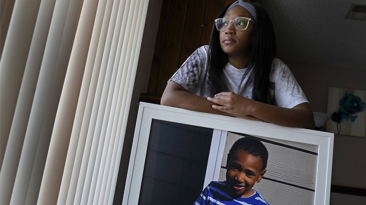 Charron Powell stands with a photo of her son, LeGend Talieferro, at her home in Raytown, Mo. LeGend was 4 years old when he was fatally shot June 29, 2020 while he was sleeping in an apartment staying with his father. (AP Photo/Charlie Riedel)