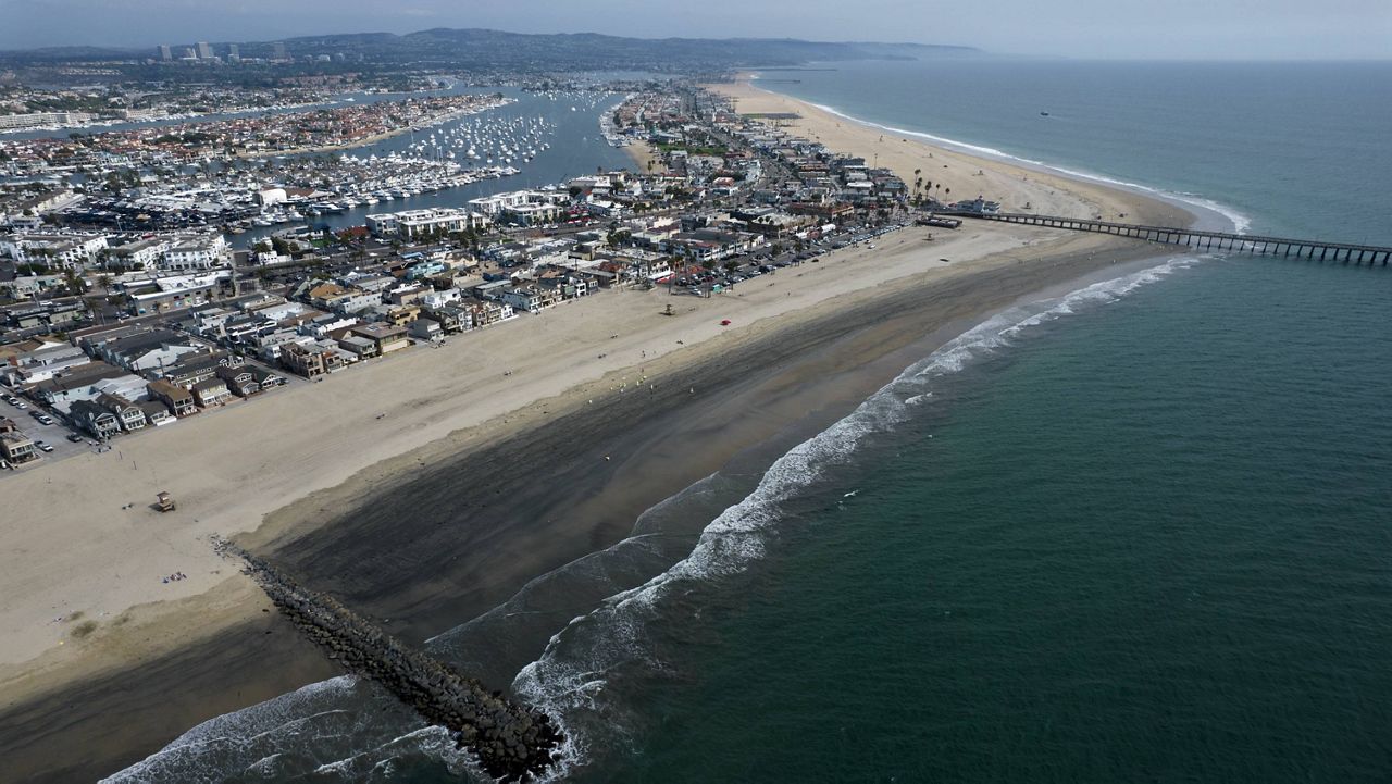 An aerial photo shows the closed beach after oil washed up on a beach in Newport Beach, Calif., on Wednesday, Oct. 6, 2021. (AP Photo/Ringo H.W. Chiu)