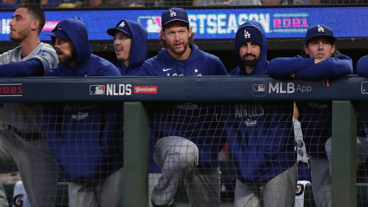 Injured Los Angeles Dodgers pitcher Clayton Kershaw, middle, stands in the dugout with teammates during Game 2 of the NLDS on Oct. 9, 2021, in San Francisco. (AP Photo/Jed Jacobsohn)