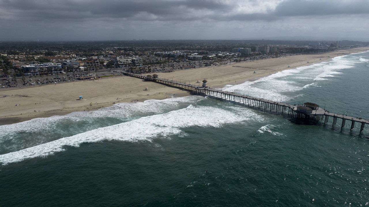 This aerial photo shows a reopened beach in Huntington Beach, Calif., Monday, Oct. 11, 2021.  (AP Photo/Ringo H.W. Chiu)