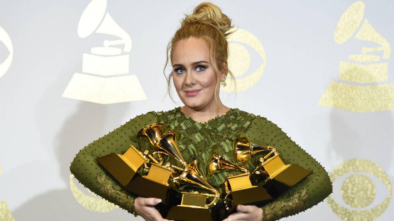 Adele poses in the press room with the awards for album of the year for "25", song of the year for "Hello", record of the year for "Hello", best pop solo performance for "Hello", and best pop vocal album for "25" at the Grammy Awards in Los Angeles on Feb. 12, 2017. (Photo by Chris Pizzello/Invision/AP, File)