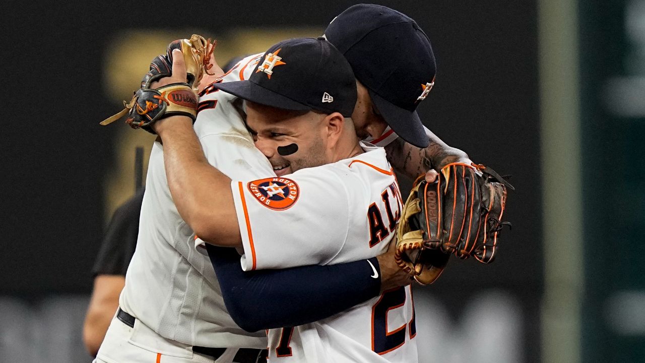 Houston Astros shortstop Carlos Correa celebrates their win with Jose Altuve against the Boston Red Sox in Game 1 of baseball's American League Championship Series Friday, Oct. 15, 2021, in Houston. (AP Photo/David J. Phillip)