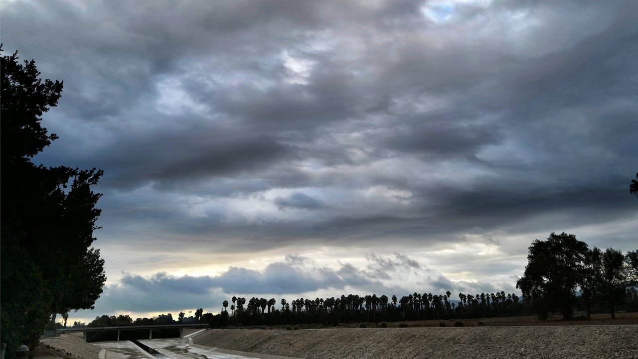 Storm clouds move over the Los Angeles river in the Encino section of Los Angeles in the early morning on Monday, Oct. 18, 2021. (AP Photo/Richard Vogel)