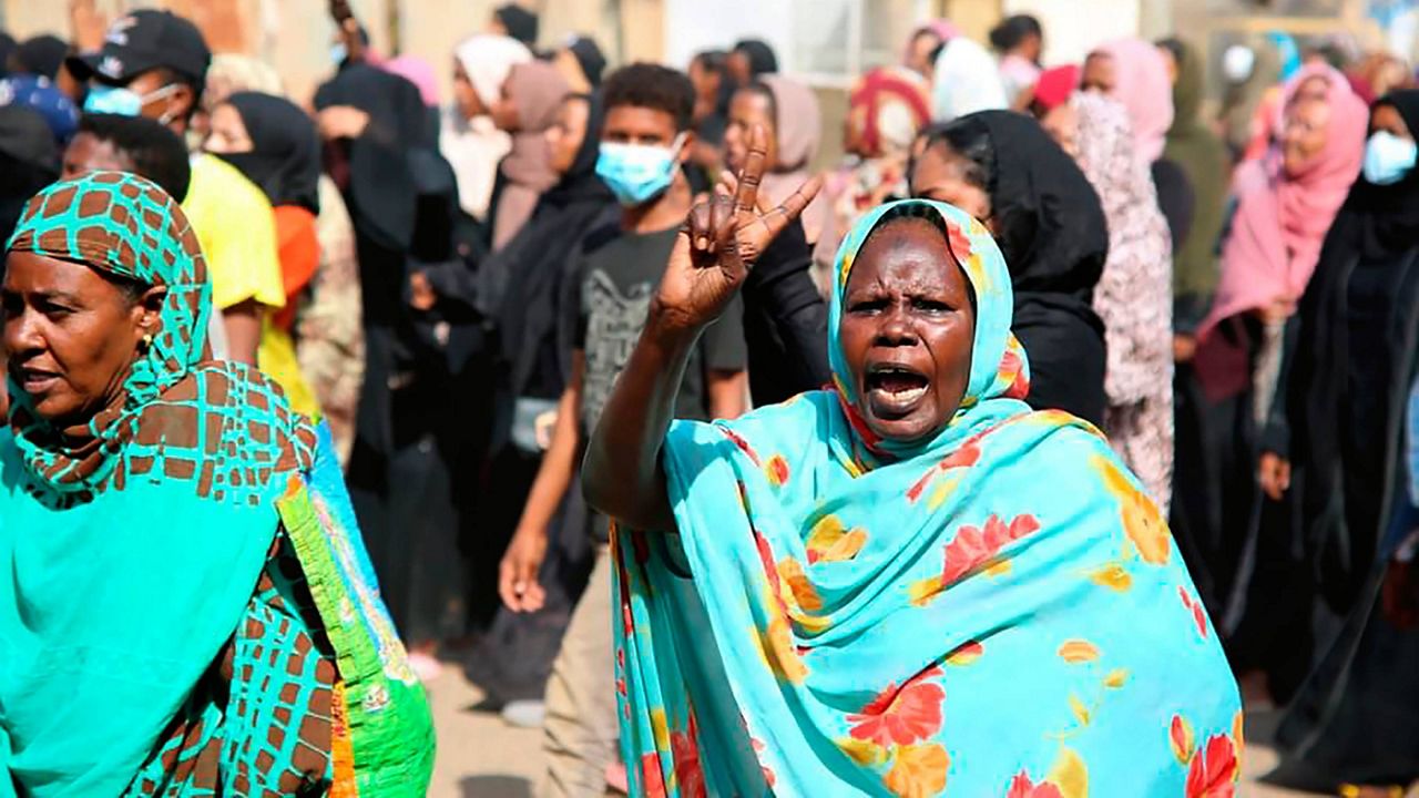 A pro-democracy protester flashes the victory sign Monday as thousands take to the streets to condemn a takeover by military officials in Khartoum, Sudan. (AP Photo/Ashraf Idris)